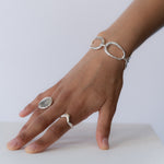 Hand with Oceania Bracelet, Terra Ring, and Selene Ring in sterling silver